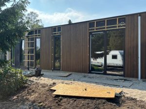 Aanbouw in Hoogblokland met houten gevelbekleding en donkere kozijnen