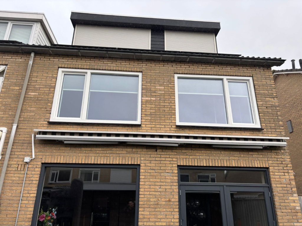 Voorgevel in Waalwijk met witte kunststof kozijnen op de verdieping